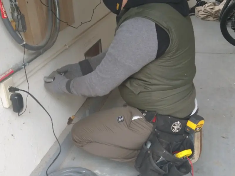Electrician performing outlet wiring in a Thomaston garage